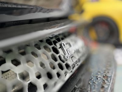 Close-up of car grill with badge and honeycomb mesh
