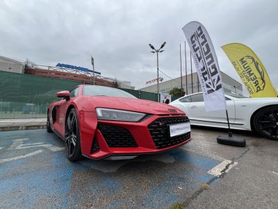 Red sports car front view with aggressive grille and LED headlights