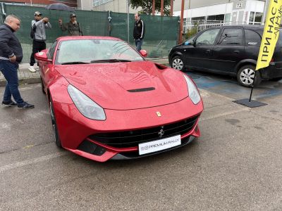 Front view of red sports car with sleek headlights and hood vent