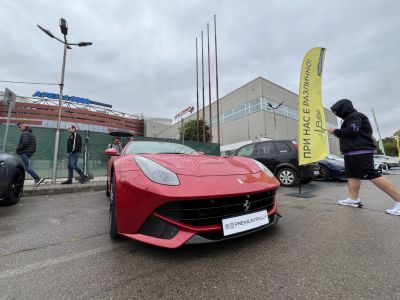 Close-up front view of a red sporty coupe with sleek headlights and wide grille