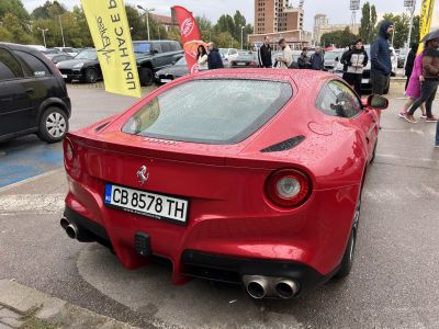 Red sports car rear with round taillights and quad exhaust pipes.