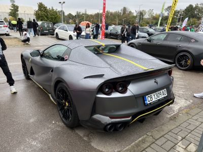 Rear view of matte silver sports car with yellow stripe and black wheels