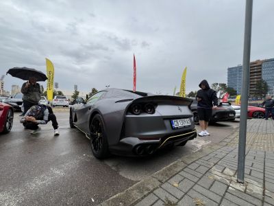 Rear view of a matte silver supercar with quad exhausts and black wheels