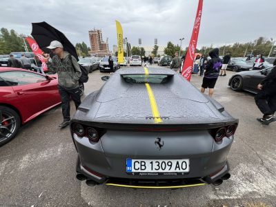 Rear of a sports car with a yellow stripe and quad exhaust