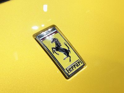 Close-up of Ferrari emblem on yellow surface