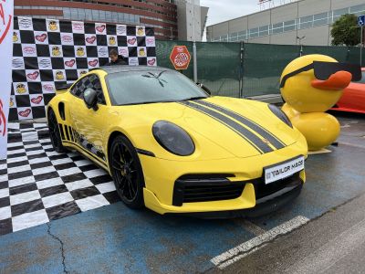 Yellow sports coupe with black racing stripes and black alloy wheels