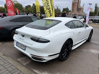 Rear and side view of a sleek luxury coupe with black alloy wheels and aerodynamic shape