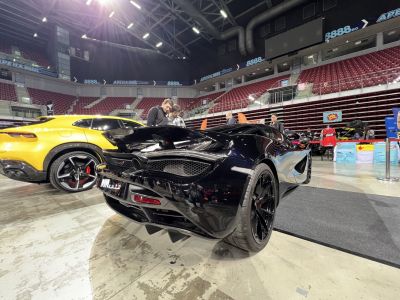 Glossy black supercar rear with aerodynamic design and performance exhausts