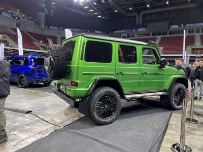 Green off-road SUV rear and side view with spare tire and black wheels