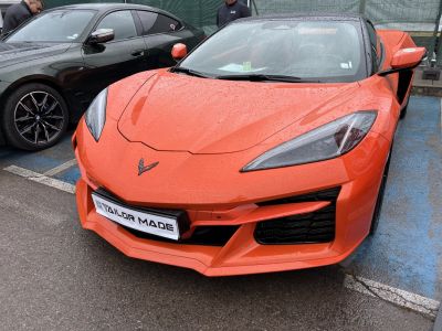 Front end with sharp headlights and aerodynamic features on an orange sports coupe