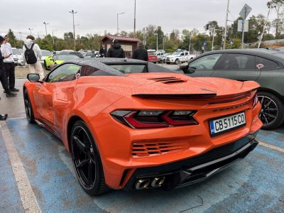 Orange mid-engine sports coupe rear with quad exhaust and sleek tail lights