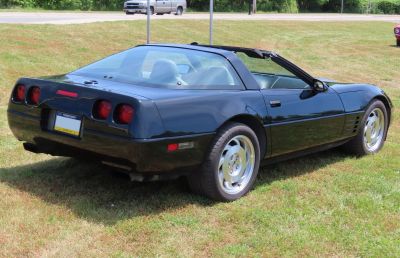 Rear side view of black Corvette Coupe with distinctive tail lights and T-top