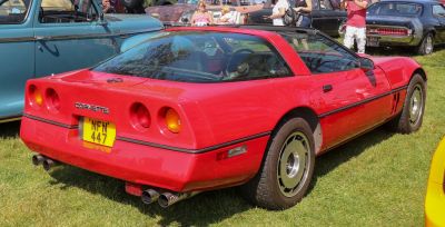 Red sports coupe rear with dual round tail lights and dual exhausts