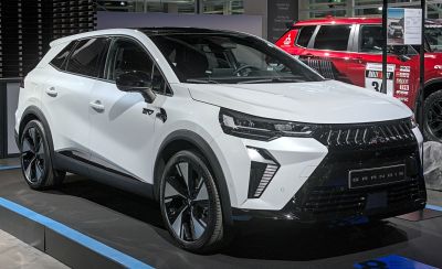 Front side view of electric SUV with sleek headlights and futuristic grille