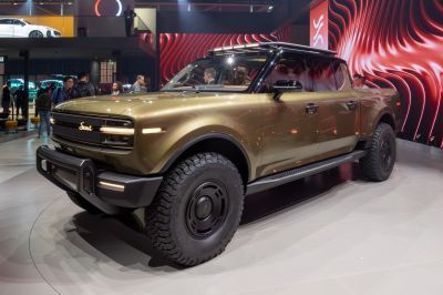 Electric pickup truck front side with distinctive grille and rugged tires