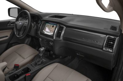 Dashboard and interior of 2023 truck with steering wheel, touchscreen, and leather seats