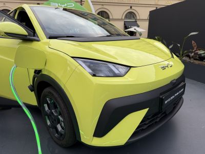 Electric charging front close-up with sleek headlight and wheel detail.