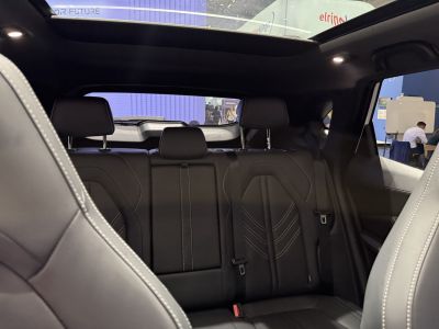 Black leather rear seats with stitching and panoramic sunroof inside car cabin