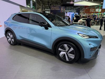 Blue aerodynamic SUV with geometric wheel design and sharp headlights