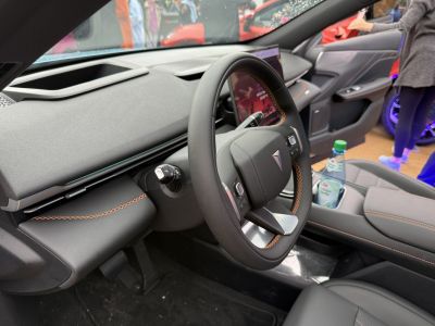 Modern steering wheel with orange stitching and digital instrument cluster