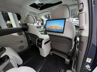 Rear passenger entertainment screens with spacious luxury seating and panoramic sunroof