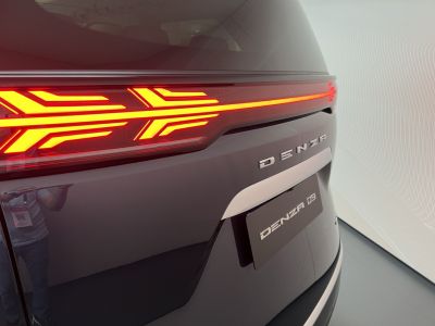 Close-up of rear LED tail light with emblem on a dark vehicle surface