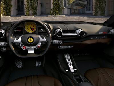 Luxury Ferrari sports car interior with digital dashboard and advanced controls