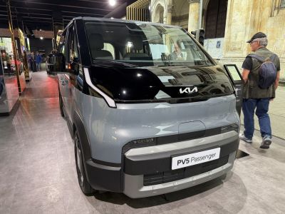 Electric microbus front view with sleek LED lights and black-gray design