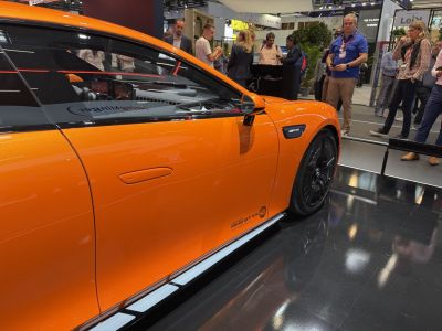 Sharp aerodynamic side profile in bright orange with black wheels.
