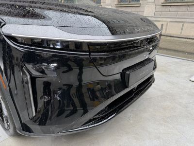 Close-up of sleek front end with integrated modern headlights and illuminated grille strip