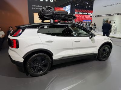 Side view of SUV with roof rack loaded with luggage and spare tire