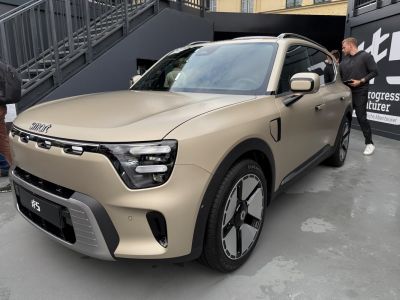 Front and side view of electric SUV with unique headlights and aerodynamic wheels.