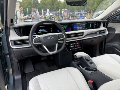 Advanced digital dashboard and steering wheel with multiple displays and white seats