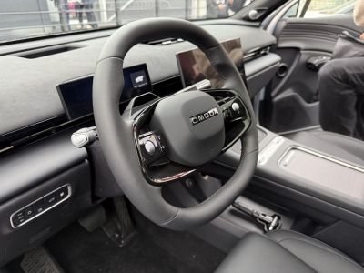 Futuristic steering wheel with digital dashboard screens and control buttons