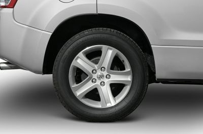 Silver alloy five-spoke wheel rim with Yokohama tire on vehicle rear.