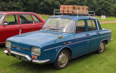 Classic sedan with rectangular headlights and roof rack with vintage suitcase