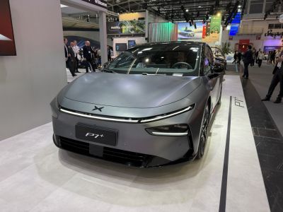 Sleek electric sedan front with streamlined LED headlights and aerodynamic design.