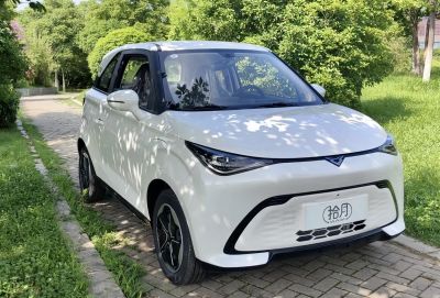 Compact electric car with sharp headlights and minimalistic front grille