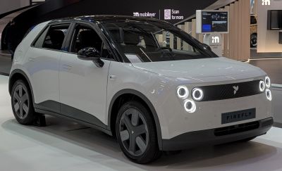 Compact electric hatchback with quad circular LED headlights and black roof contrast