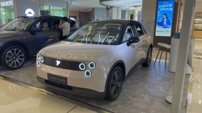 Sleek electric crossover with quad circular LED headlights and two-tone paint.