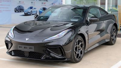 Glossy black sporty coupe with sharp headlights and aggressive front air intakes