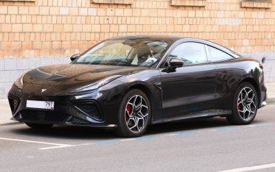 Sleek black sports coupe with sharp headlights and unique geometric alloy wheels