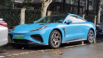 Front-side view of sporty electric coupe with sleek headlights and aerodynamic design