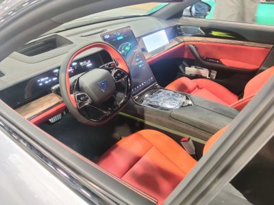 Digital instrument cluster and large vertical touchscreen in red seat interior