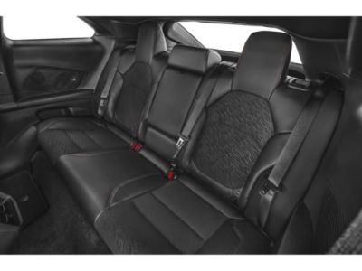Rear leather seats with armrest and seat belts in a muscle car.