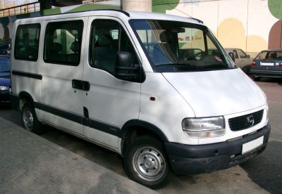 White passenger van with large windows and sliding side doors.