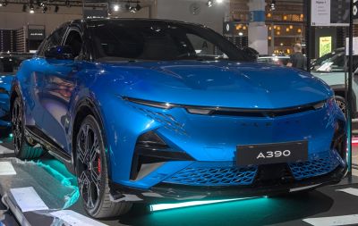 Sleek blue electric SUV with sharp LED headlights and futuristic front grille