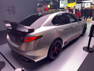 Rear-side view of sedan with carbon fiber spoiler and sporty alloy wheels