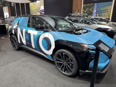 Electric SUV with blue and black wrap, modern alloy wheels.