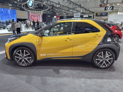 Side profile of compact SUV with sporty alloy wheels and two-tone yellow-black paint.
